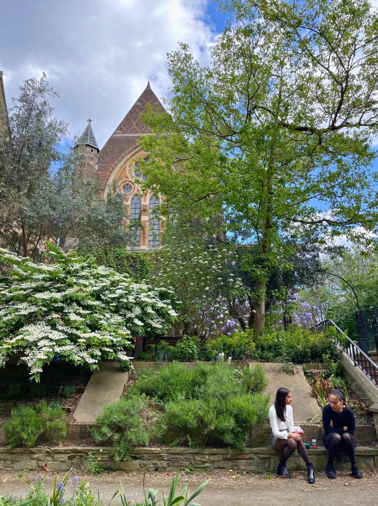 leafy green park with a church in East London