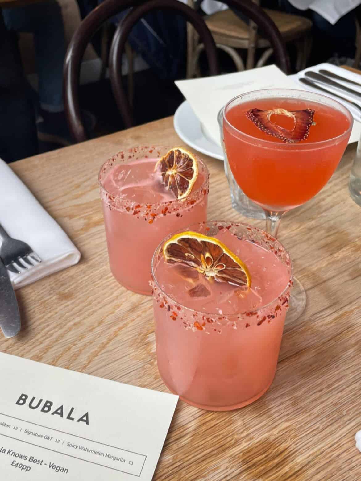Pink margaritas on a table in a restaurant called Bubala in London