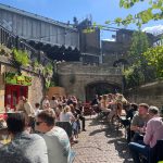 A busy pub garden in London, sun shining