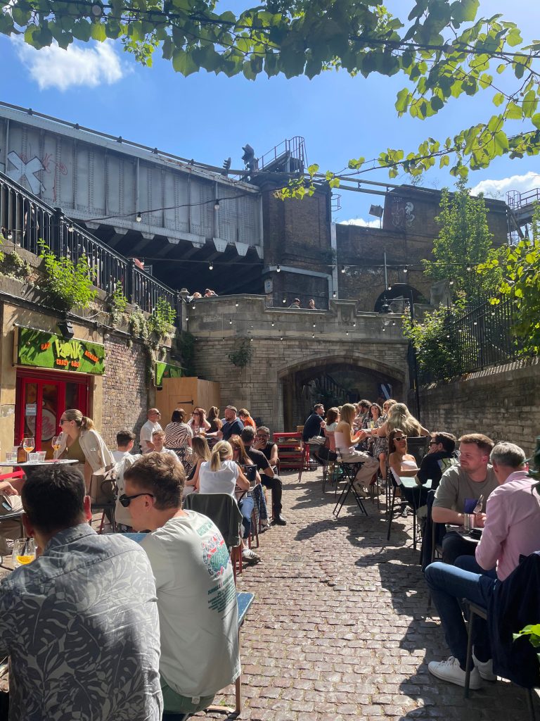 A busy pub garden in London, sun shining