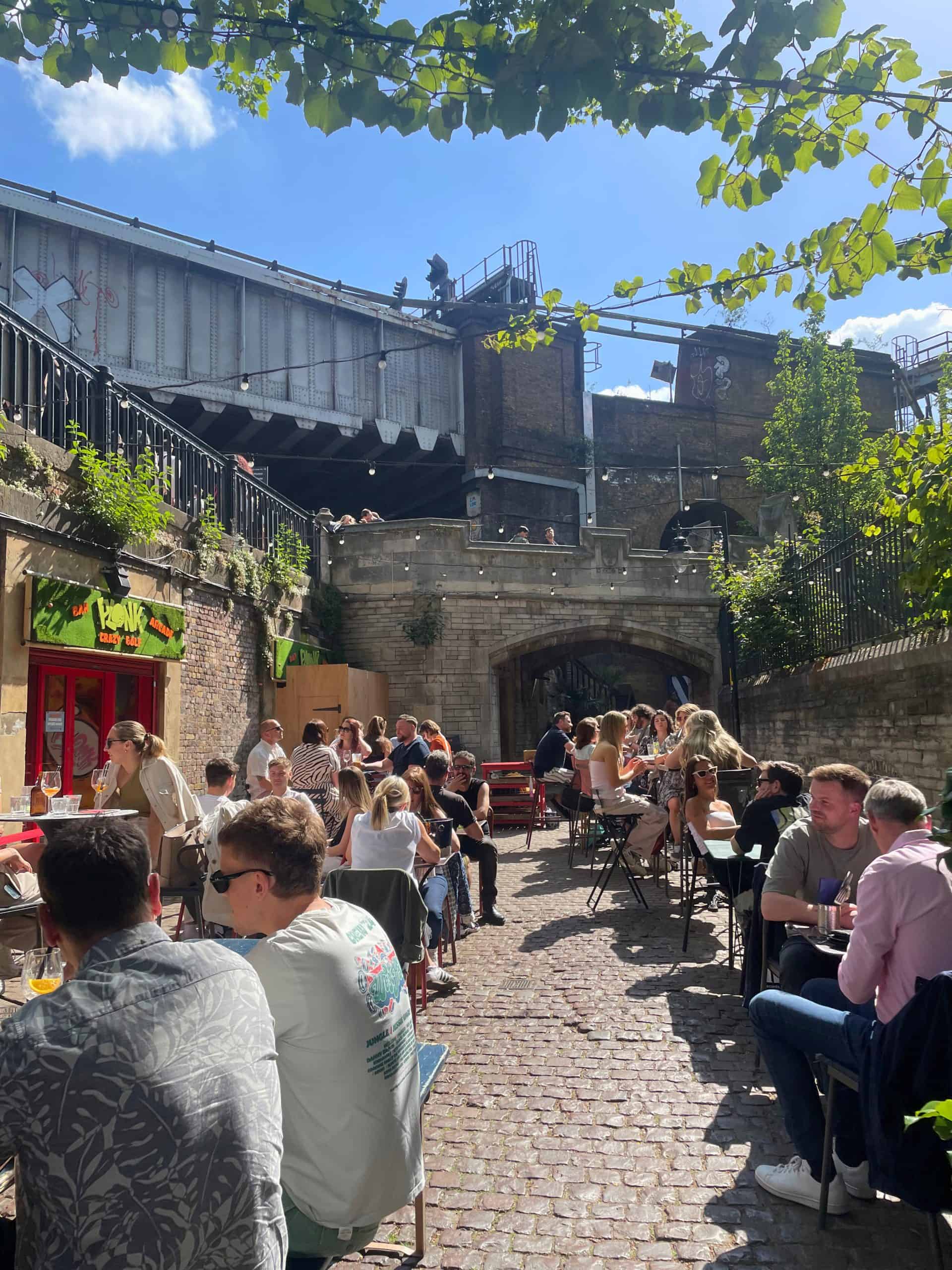 A busy pub garden in London, sun shining